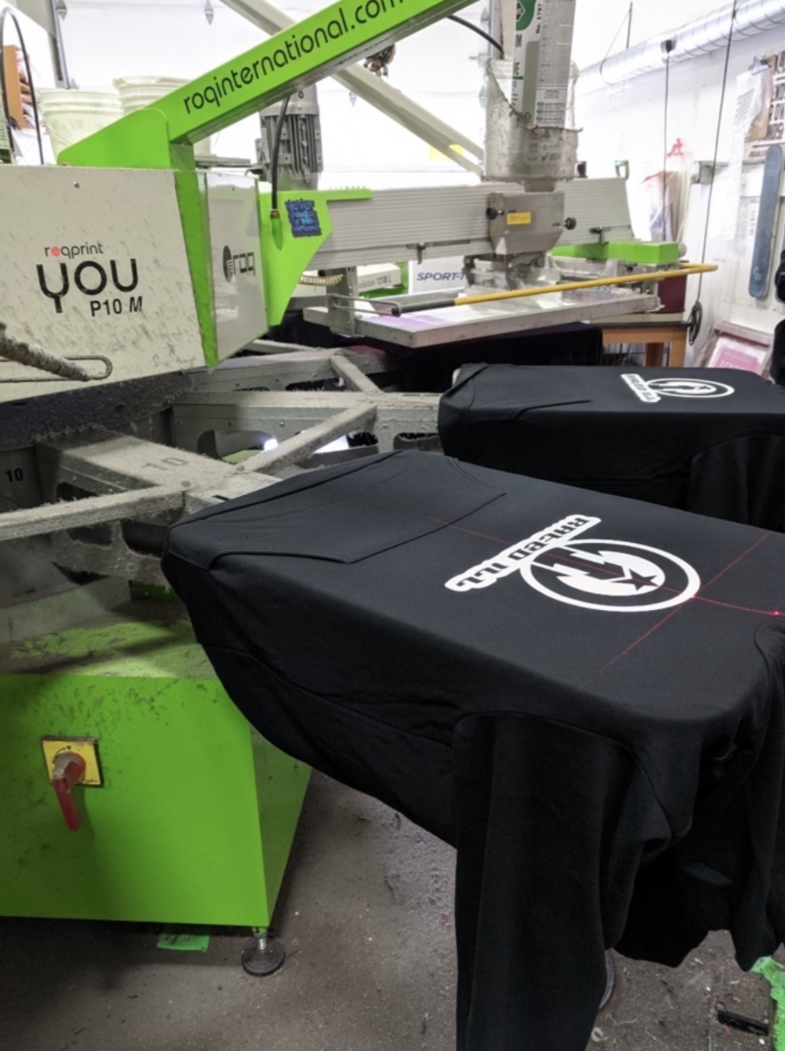 Screen printing press with black shirts on platens