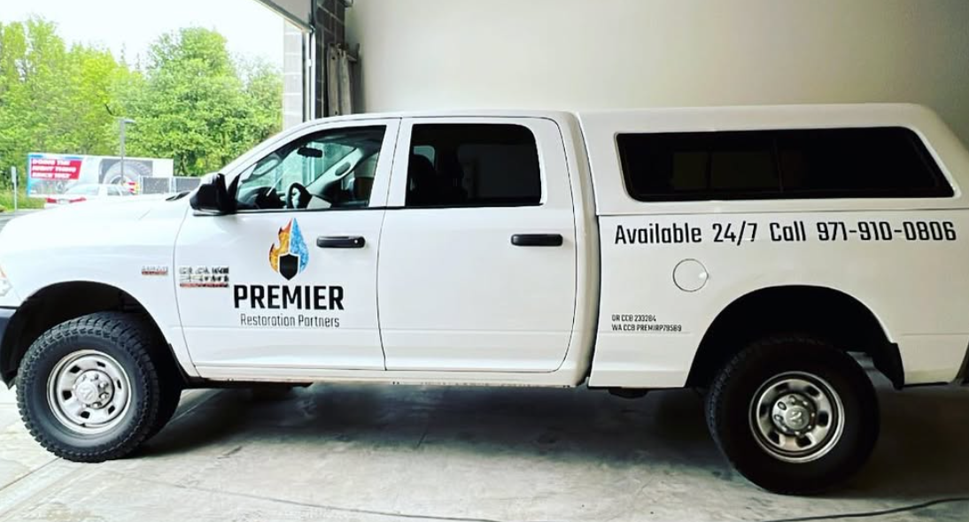 White service truck with Premier Restoration Partners vehicle lettering and logo