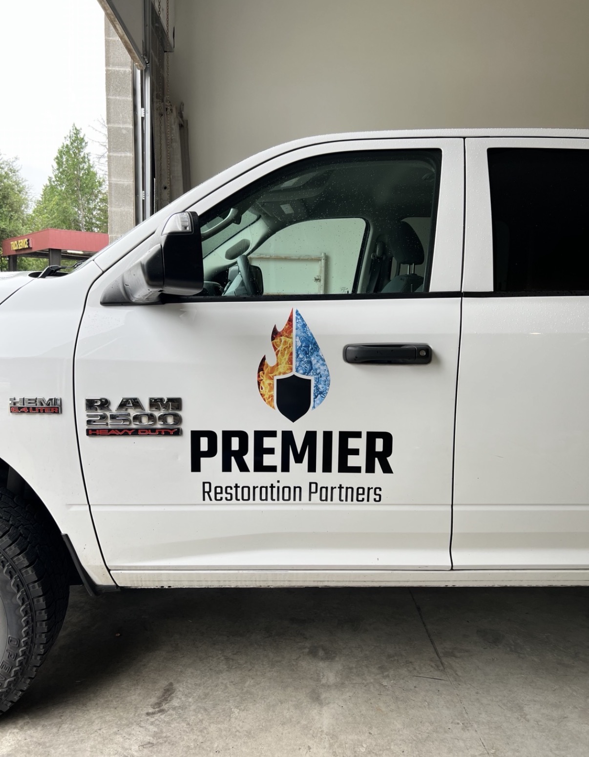 Premier Restoration Partners white service truck with lettering